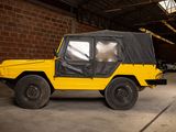 a yellow jeep with a black cover parked in a garage