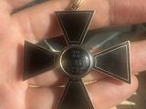 a person holding a black and gold cross in their hand