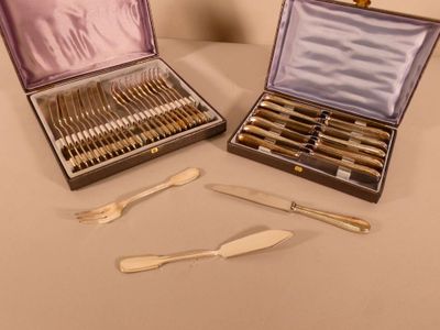 deux sets d'argenterie dans un coffret sur une table