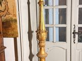 une bougie dorée posée sur un support devant une porte