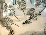 many fish in a glass bowl with leaves on it