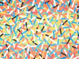 colorful sprinkles are scattered on an orange background