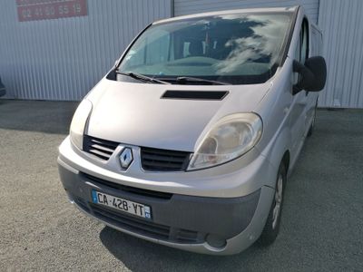une camionnette argentée garée devant un immeuble