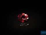 un diamant rouge sur une surface noire