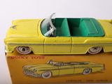 yellow and green toy car with open top in box on white surface