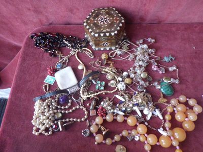 a pile of jewelry on a table with a red cloth