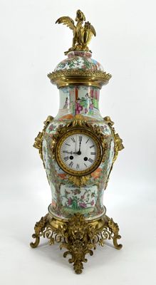 une horloge posée sur un support sur une surface blanche