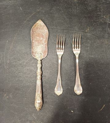 trois fourchettes et une cuillère sur une table