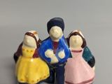 three figurines of people sitting together on a table