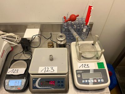 trois balances électroniques posées sur un comptoir, avec une échelle de mesure