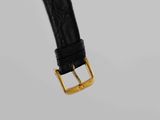 a close up of a black watch strap with a gold buckle