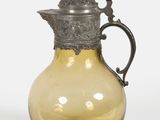 un pichet en verre jaune avec un couvercle en argent, sur fond blanc