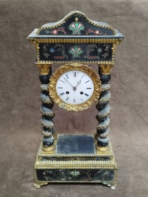 une horloge posée sur un support sur une table