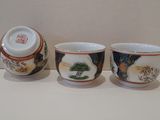 three cups with designs on them are sitting on a table