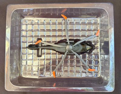 une petite maquette d'hélicoptère dans un récipient en plastique