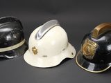 three firemen hats are lined up against a black background