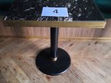 une petite table sur laquelle est inscrit un chiffre, posée sur un parquet