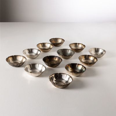 des bols plaqués argent disposés en cercle sur une surface blanche