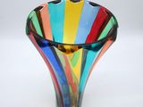 a multicolored glass vase sitting on a white surface