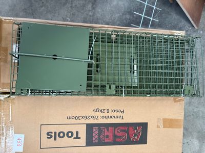 a box with a cage on top of it on the ground