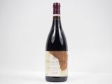 une bouteille de vin rouge posée sur une table blanche