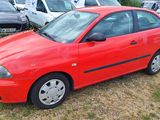 a red car that is parked in the grass
