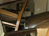 a pile of wooden chairs and a clock in a room