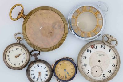 many different types of pocket watches on a white surface