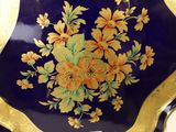 a blue and gold plate with yellow flowers on it