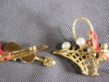 pair of gold tone earrings with pearls and bows on a gray surface