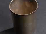 a close up of a metal cup on a black surface
