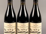 trois bouteilles de vin sont alignées sur une table