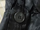 the jacket is black and has a button on it