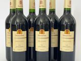 six bouteilles de vin sont alignées sur une surface blanche