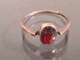 a silver ring with a red stone in it