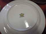 une assiette blanche ornée d'une couronne, posée sur une table