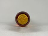 a close up of a red and gold ball on a white surface