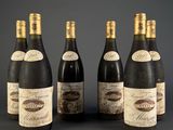 six bouteilles de vin sont alignées sur une table