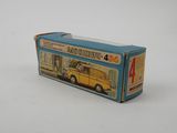a toy bus that is in a box on a white surface