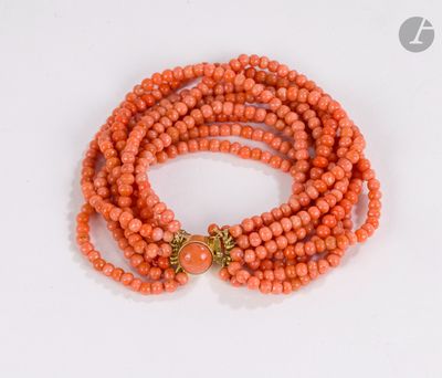 a close up of an orange beaded bracelet with a gold clasp