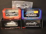 three silver cars are sitting in boxes on a black surface