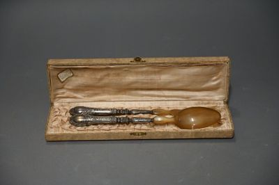 une boîte en bois contenant une cuillère en métal et une cuillère en bois