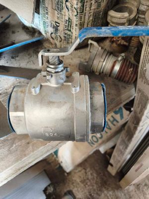 un robinet à bille en métal posé au sommet d'un tas de ferraille