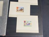 several different stamps are displayed in a folder on a table