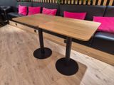 une table en bois sur laquelle sont posés des coussins roses, dans une pièce