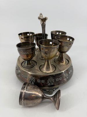 a silver plate with cups and spoons on it