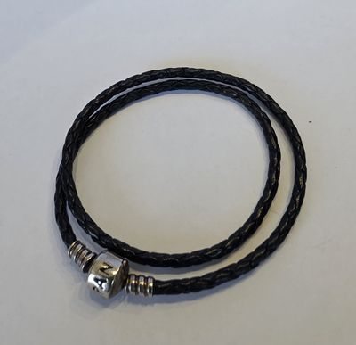a close up of a black leather bracelet with a silver clasp