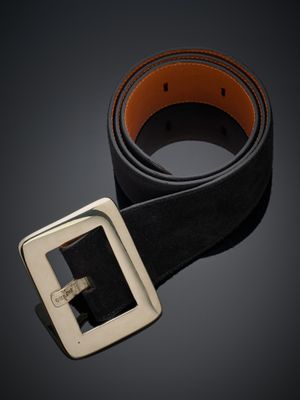 une ceinture en cuir noir avec une boucle argentée sur fond sombre