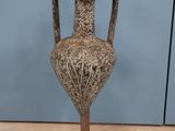 un vase posé sur un socle au sol