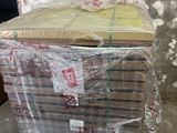 une pile de livres emballés dans du plastique, posée par terre